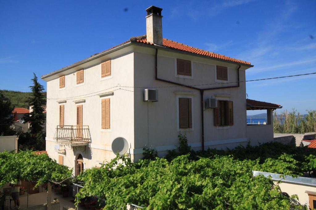 a white house on top of a hill with vines at Family friendly seaside apartments Susak, Losinj - 8050 in Susak