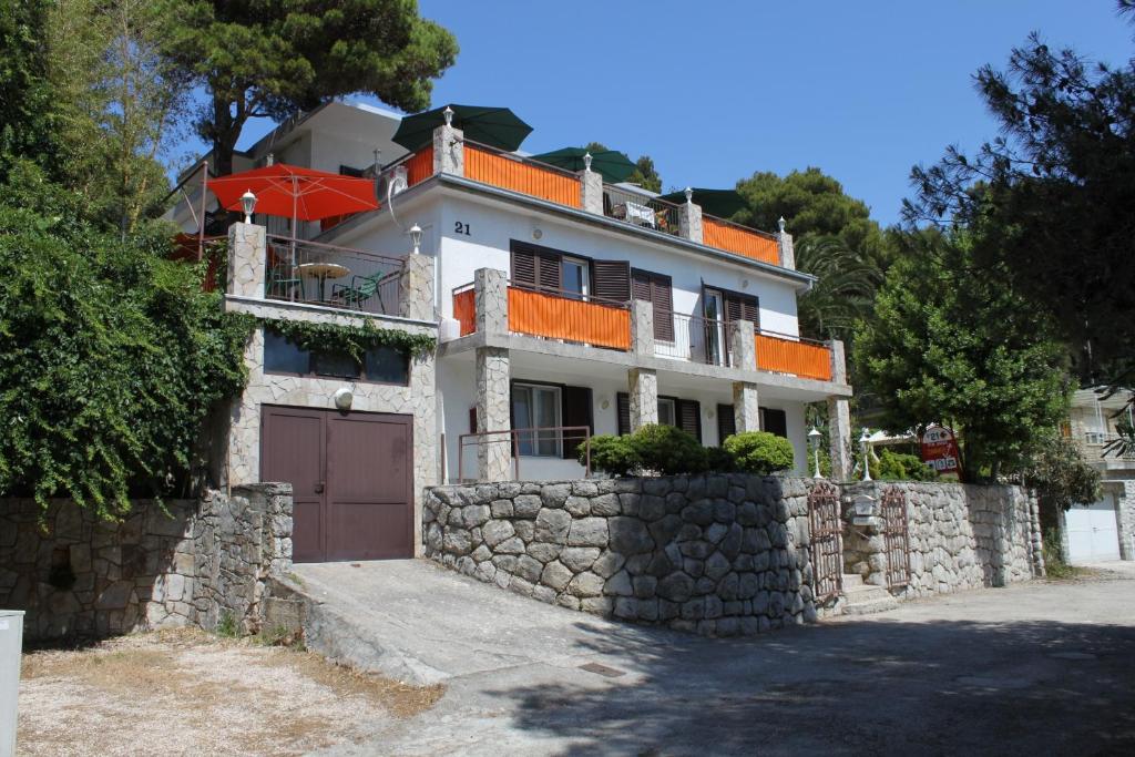 a house on a stone wall with a gate at Apartments and rooms by the sea Mali Losinj (Losinj) - 7953 in Mali Lošinj