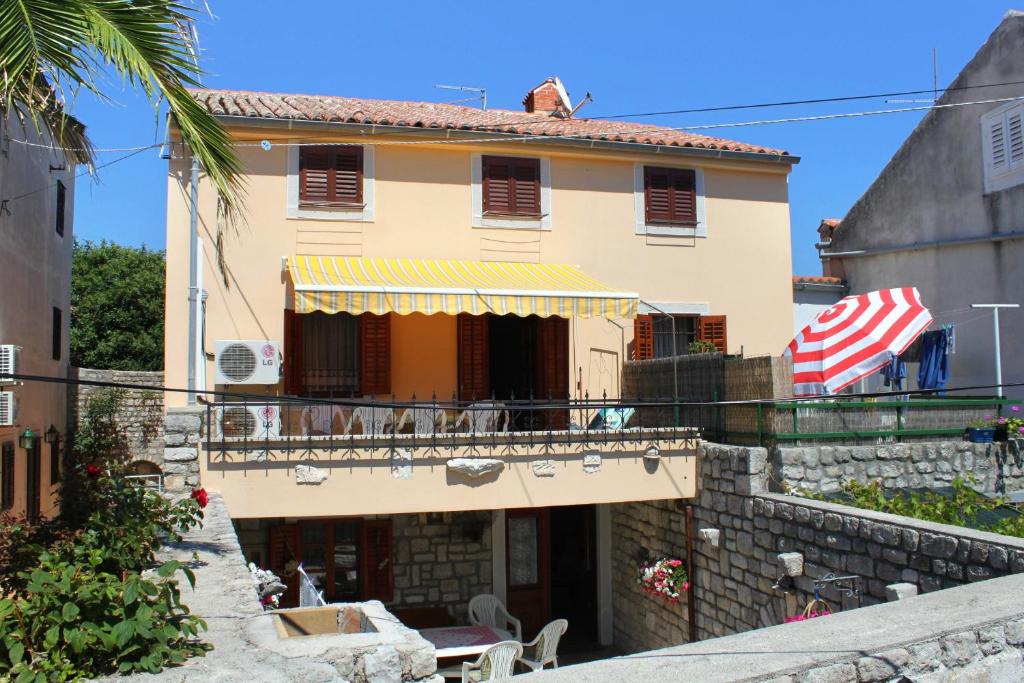 uma casa com uma bandeira americana na varanda em Apartments by the sea Osor, Losinj - 8088 em Nerezine