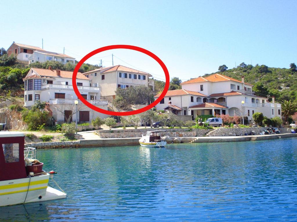 a red circle over a body of water with houses at Apartments by the sea Zaglav, Dugi otok - 8191 in Sali