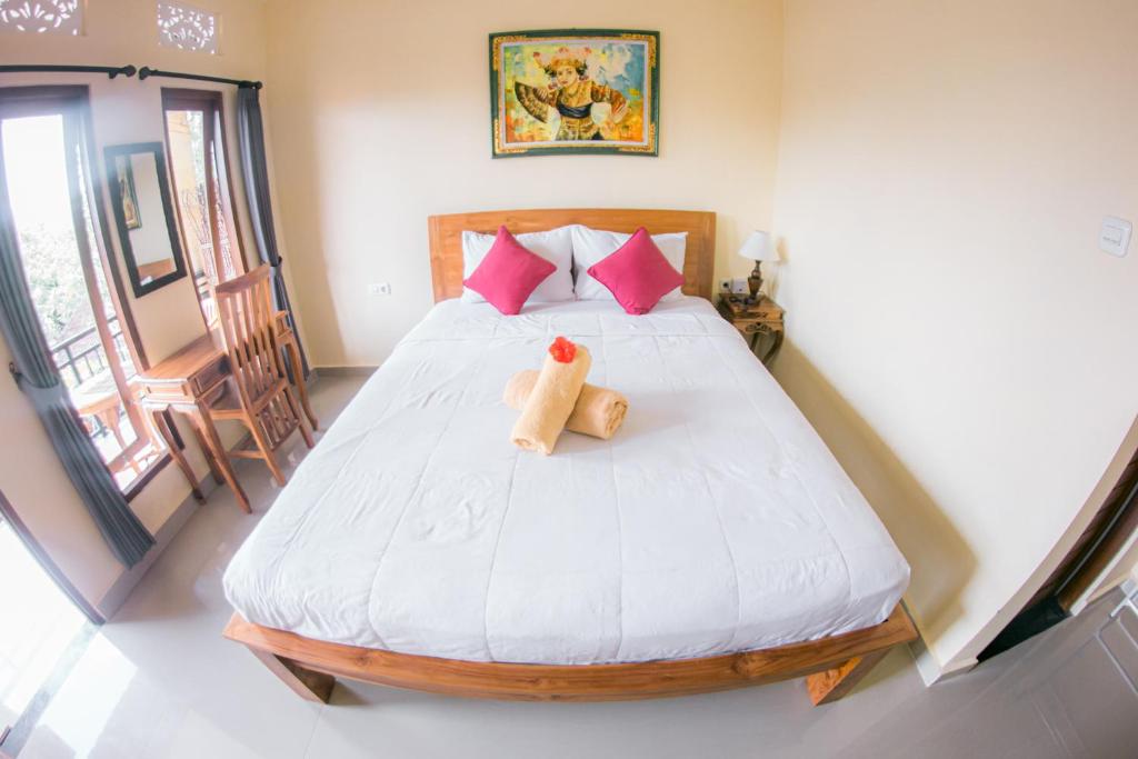 una camera da letto con un letto con due peluche sopra di Witantra house ad Ubud