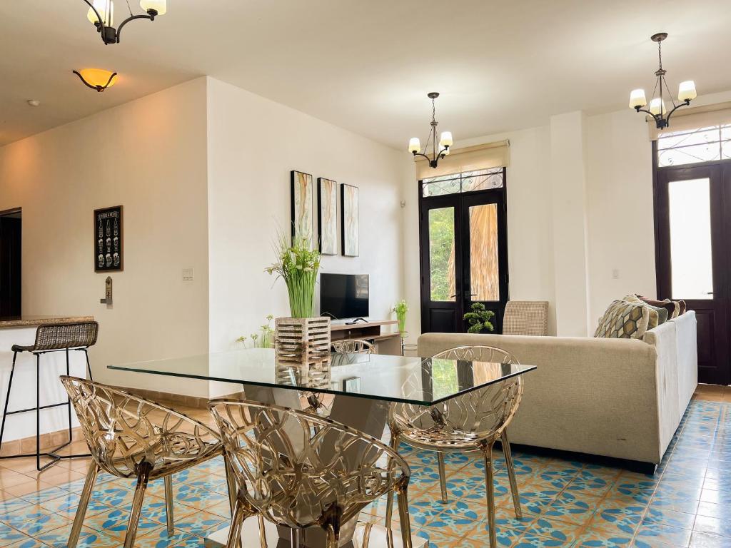 uma sala de estar com uma mesa de vidro e cadeiras em Apartamento en el Corazón de Casco Viejo Panamá 10 na Cidade do Panamá