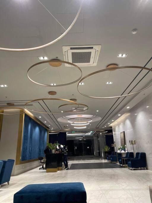 a large lobby with blue chairs and a lobby at Minimalist Cozy Condo Studio Unit in Grand Residences Cebu in Cebu City
