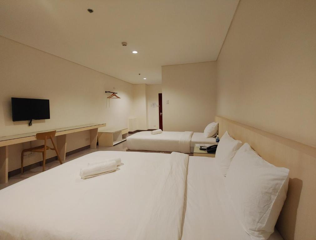 Postel nebo postele na pokoji v ubytování Kaizen Suites