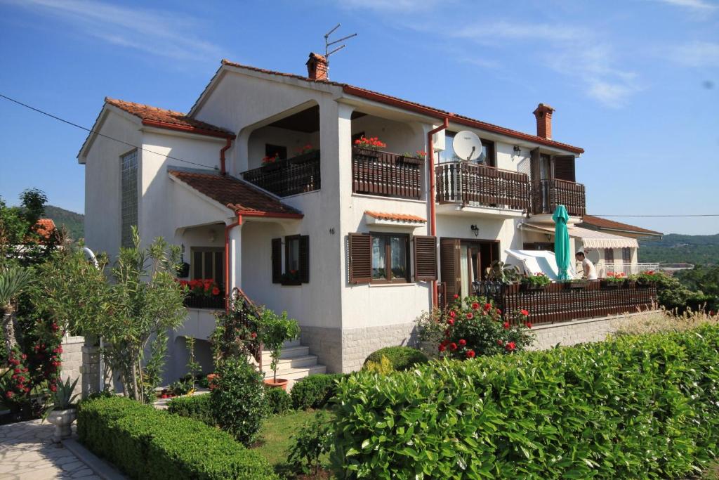 uma casa branca com uma varanda numa colina em Apartments for families with children Opatija - Pobri, Opatija - 7890 em Matulji