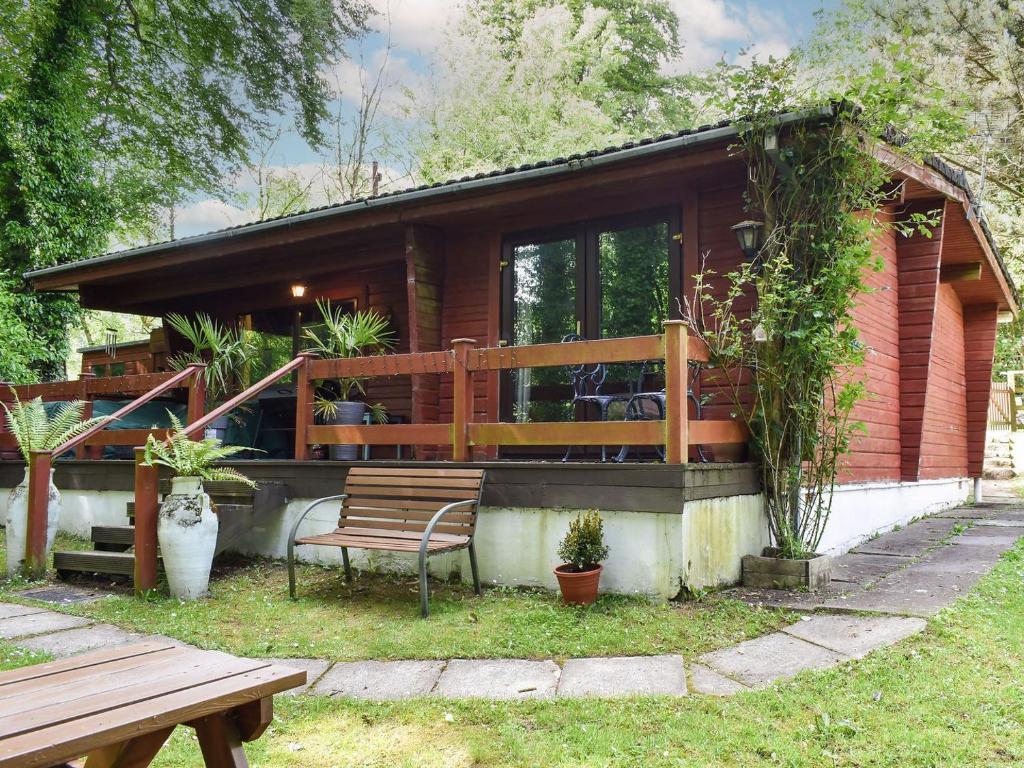 a wooden house with a bench in the yard at Finlog in Bradworthy