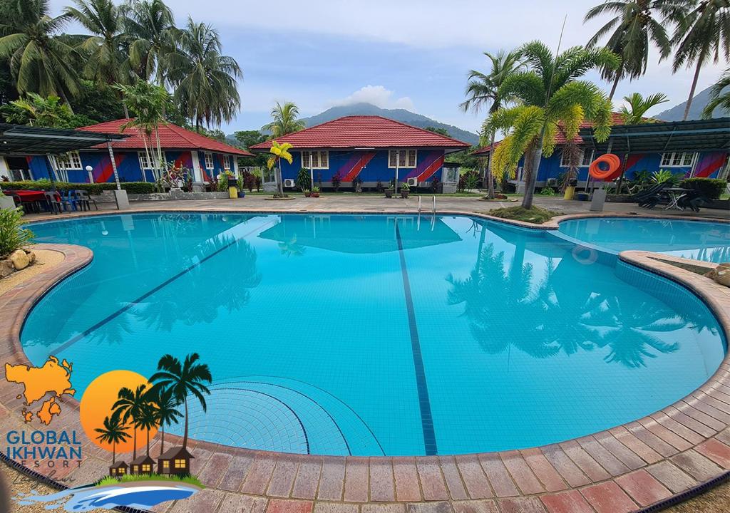 a large blue swimming pool in front of a resort at GLOBAL IKHWAN RESORT in Kuah