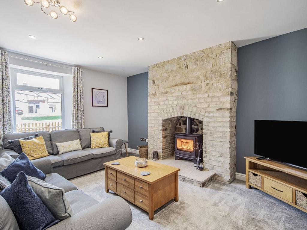 a living room with a couch and a fireplace at Emmaville in Ryton