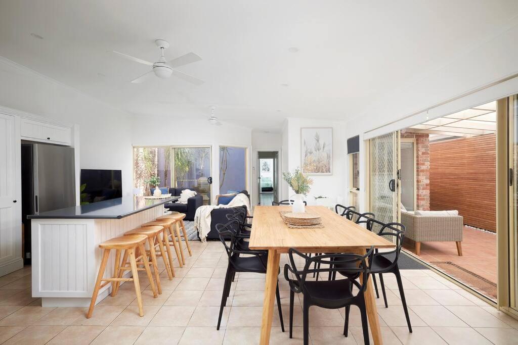 een keuken en een woonkamer met een tafel en stoelen bij The Atrium in Shoal Bay