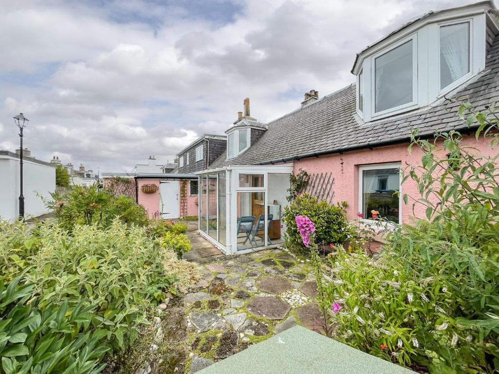 a pink house with a garden in front of it at Pink Cottage in Nairn