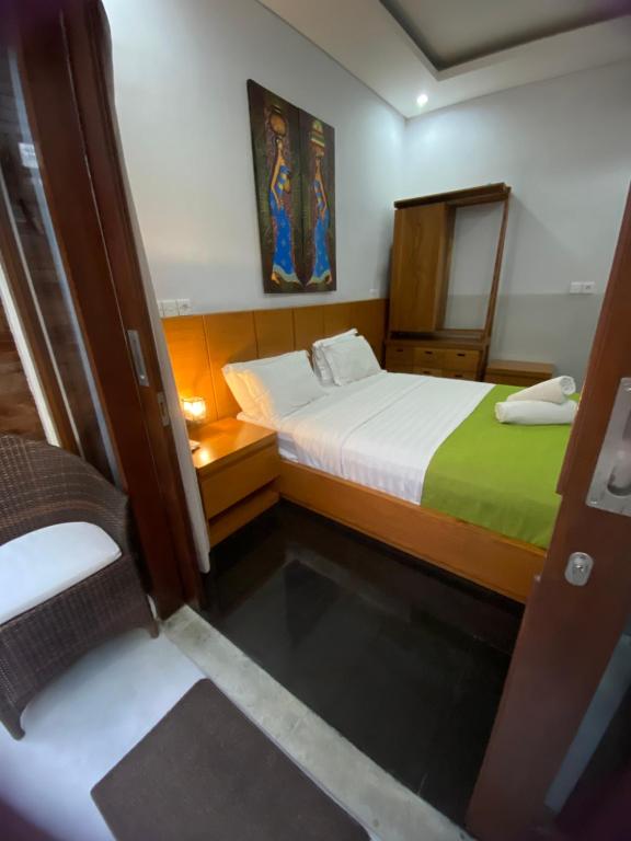 Cette petite chambre comprend 2 lits et un miroir. dans l'établissement Rahayu Guest House Seminyak, à Seminyak