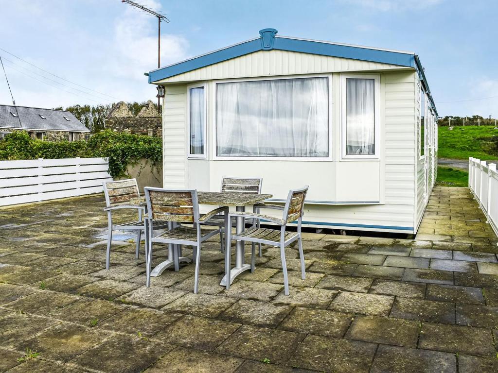 a table and chairs in front of a caravan at Methlem Chalet in Aberdaron