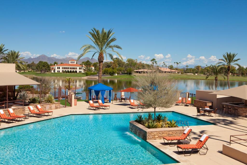 einen Pool in einem Resort mit Stühlen und einem See in der Unterkunft The McCormick Scottsdale in Scottsdale