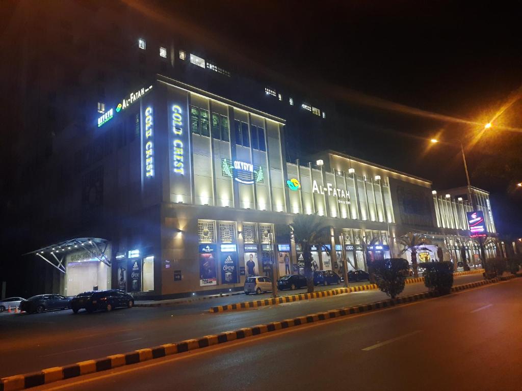 Goldcrest Luxury Apartments في لاهور: مبنى يتم تشغيله في مدينة في الليل