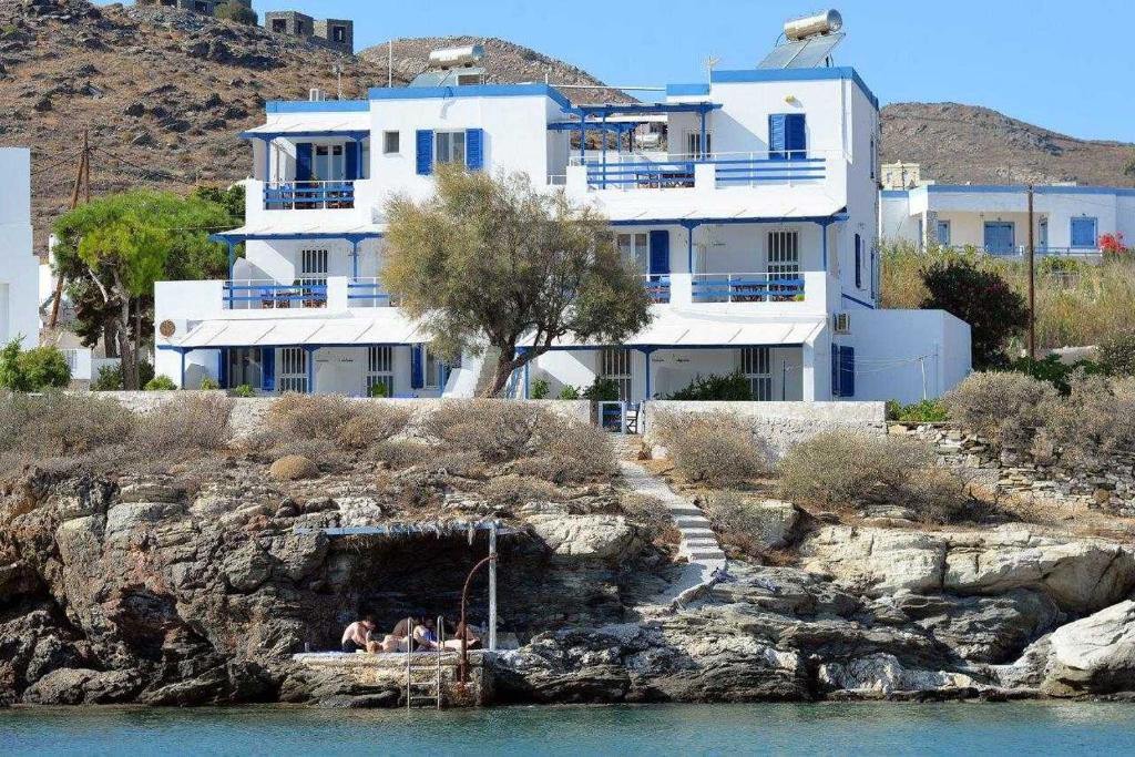 een groot wit huis op een heuvel naast het water bij Peaceful Bay in Megas Gialos - Nites