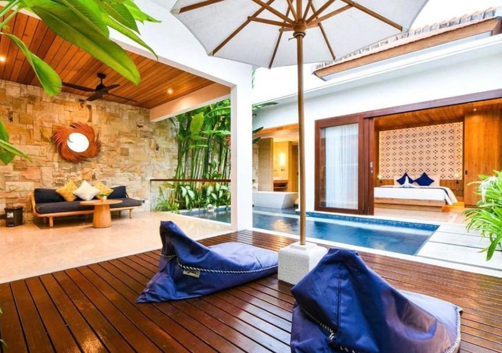 a villa with a swimming pool and a living room at The Mavila - CHSE Certified in Sanur