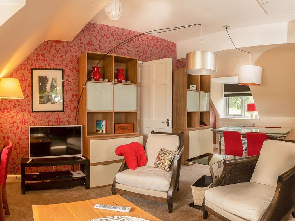 een woonkamer met een bank en een tv bij Apartment Hole 18 3-4 in Nailsworth