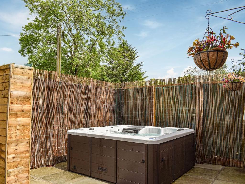 a hot tub in a backyard with a fence at Highgate in Brynkir