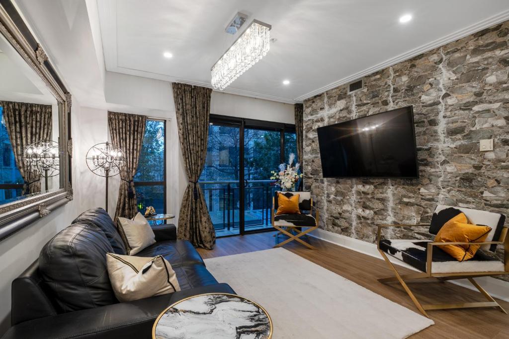a living room with a stone wall at The Celebrity in Auckland