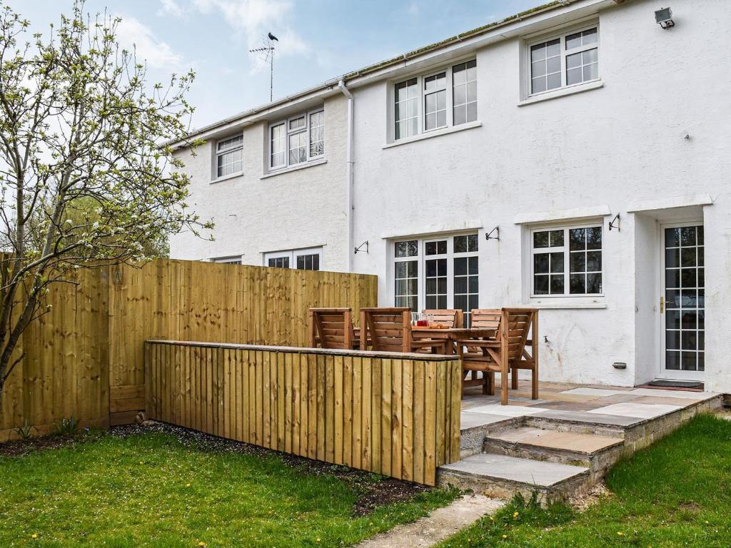 a wooden fence in front of a white house at Brookside in Coychurch