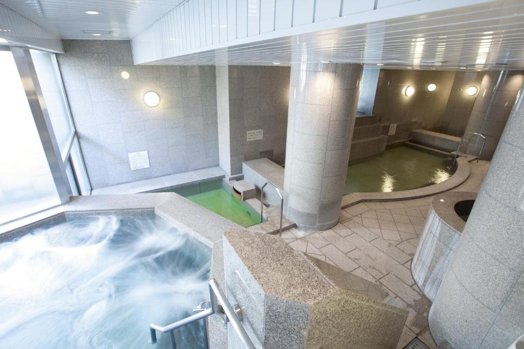 HOTEL MYSTAYS PREMIER Sapporo Park في سابورو: حوض استحمام ساخن على سفينة سياحية مع تجمع للمياه