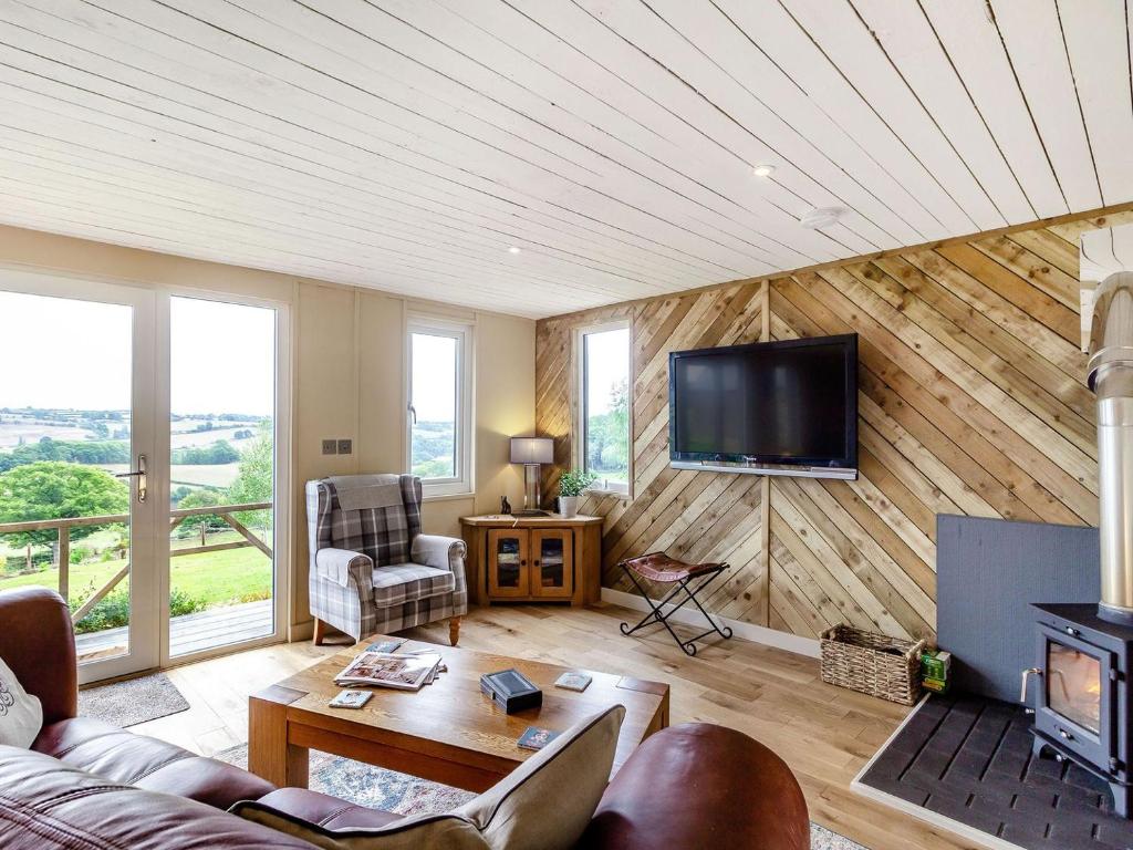 a living room with a couch and a tv on a wall at The Workshop in Garway