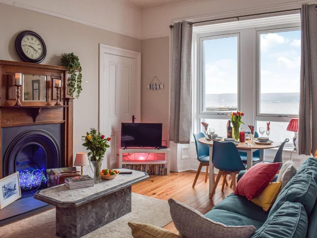ein Wohnzimmer mit einem Sofa und einem Tisch in der Unterkunft The Seaside Suite in Helensburgh