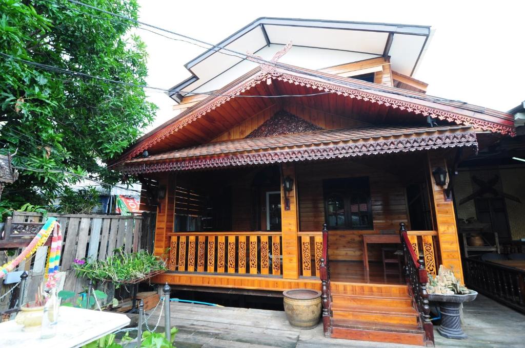 a wooden house with a porch and a balcony at Kaloang home in Bangkok