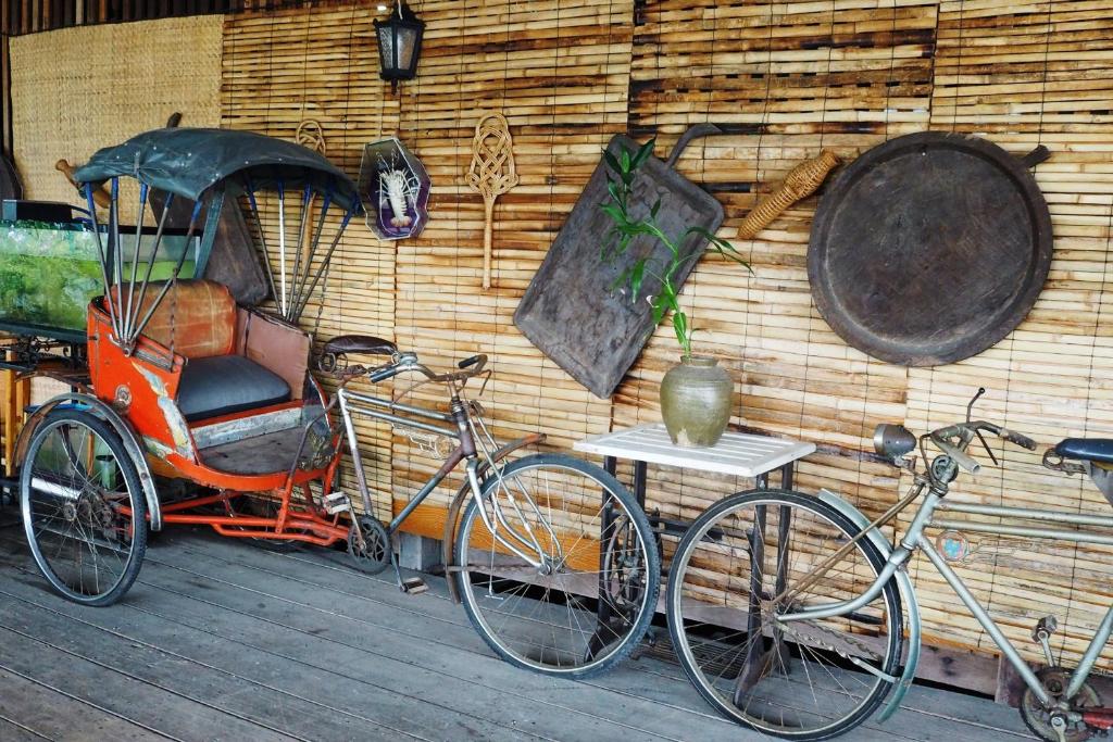 two bikes parked next to a wall with a rickshaw at Kaloang home in Bangkok