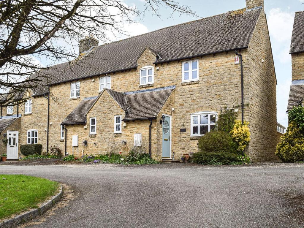 a large brick house with a driveway at Primrose Cottage in Little Rissington