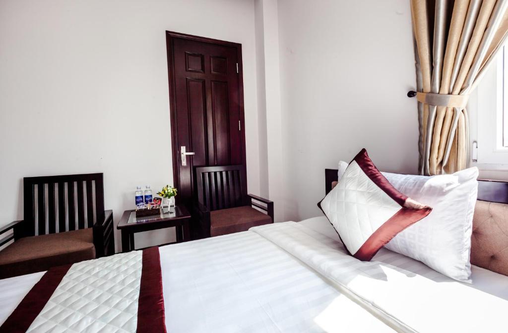 1 dormitorio con cama con almohada y silla en Night Sky Hotel, en Da Nang