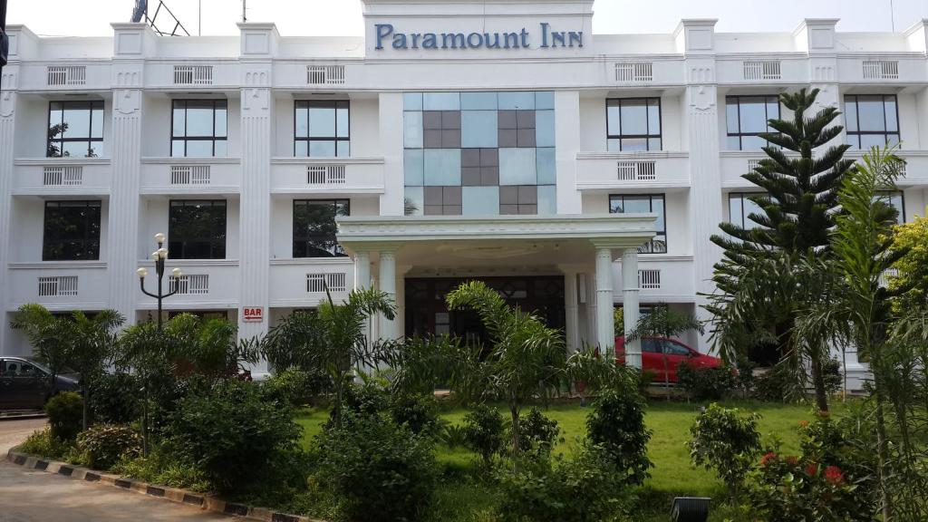 un edificio blanco con un cartel. en Paramount Inn, en Sriperumbudur