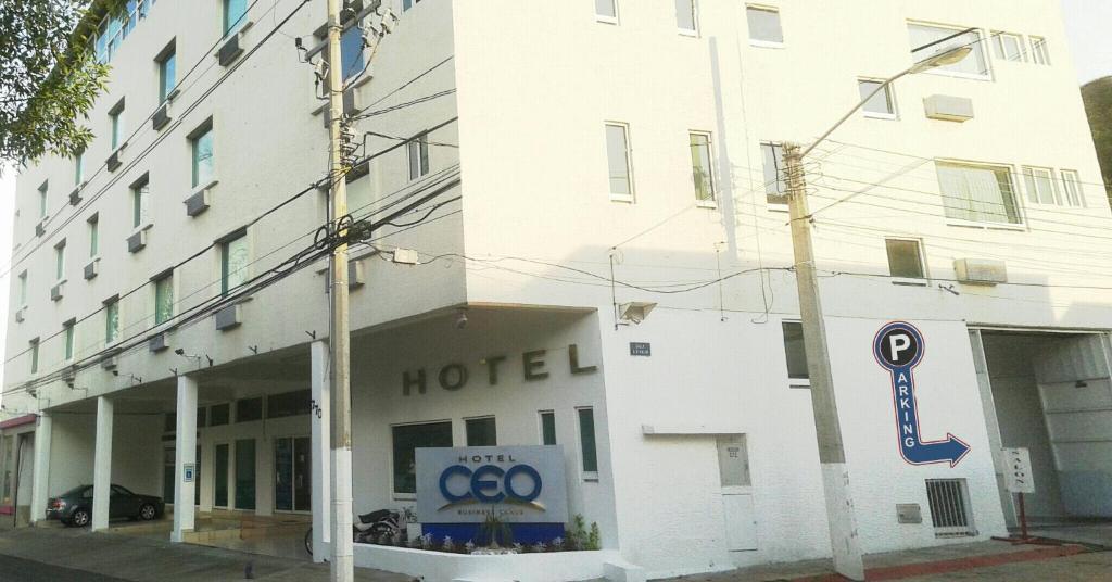 un edificio blanco con un cartel de hotel delante en Hotel CEO en Morelia
