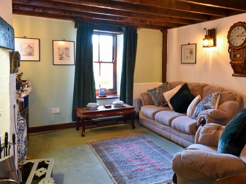 a living room with a couch and a table at Robsons Cottage in Alston