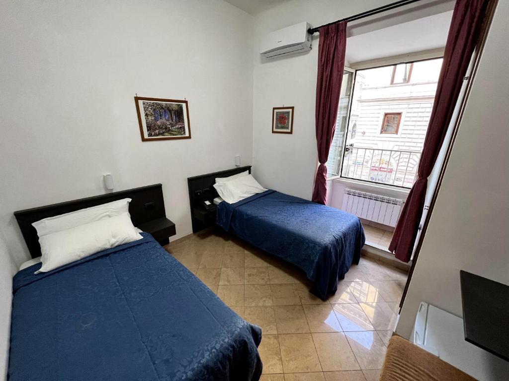 Postel nebo postele na pokoji v ubytování Hotel domus termini
