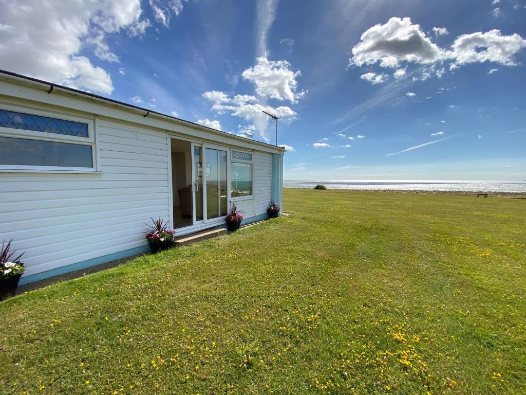 una casa con un gran patio junto al océano en Sea Pearl en Kessingland