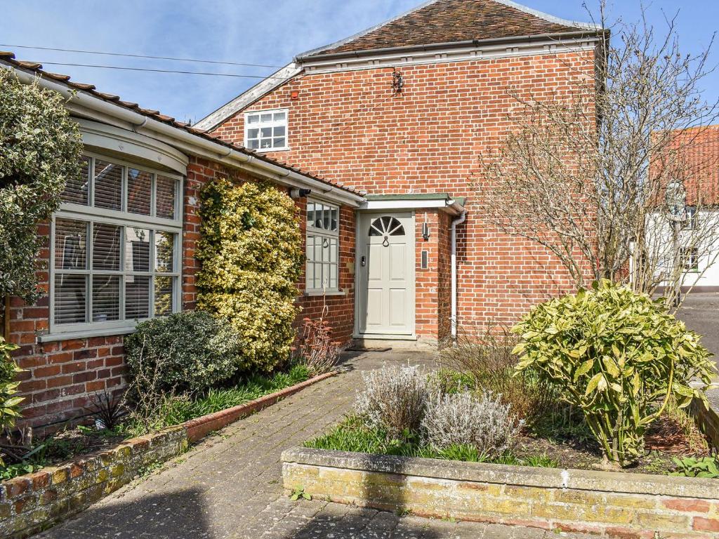 a red brick house with a white door at May Cottage in Rendham