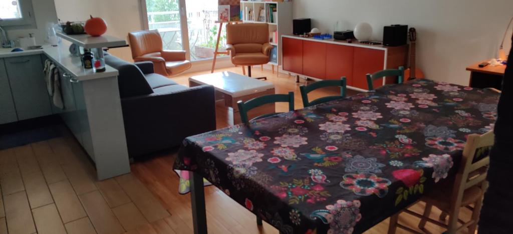 uma cozinha e uma sala de estar com uma mesa e uma cozinha em Chambre chez l'habitant a 5 minutes du métro em Ivry-sur-Seine