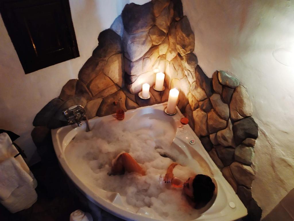 y baño con bañera con velas. en El escondite de Martina, Casa Rural Romántica, en Setenil