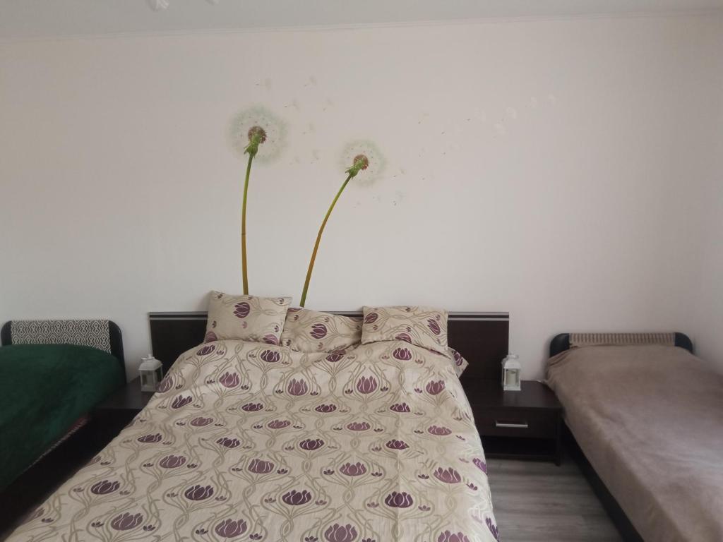 ein Schlafzimmer mit einem Bett mit Blumen darauf in der Unterkunft Kiss-Szőllősi Vendègház in Debrecen