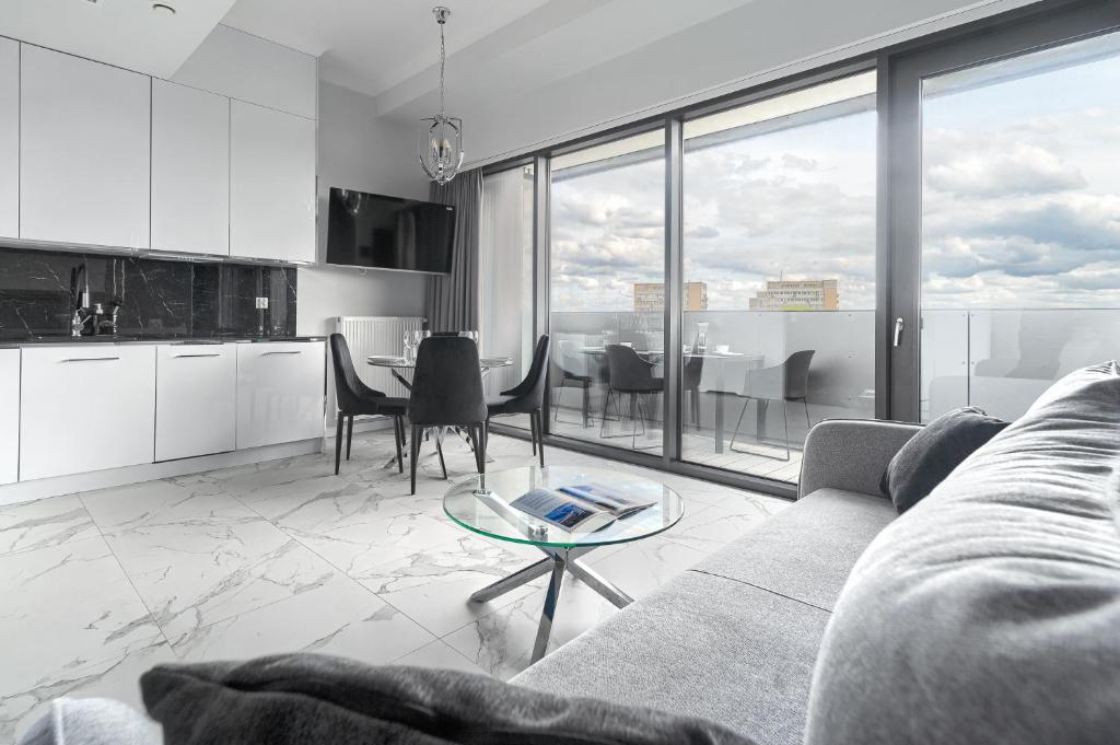 una sala de estar con un sofá y una mesa en Apartament w Hanza Tower, en Szczecin