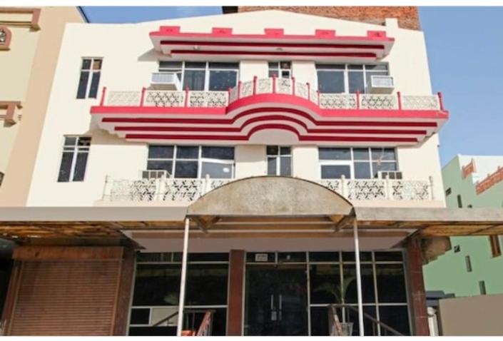 een hoog gebouw met een rood en wit bij Hotel Apoorva DLX in Jaipur