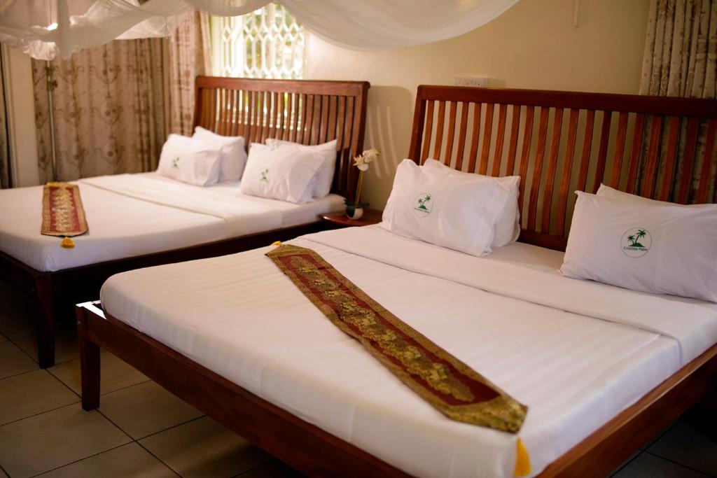 Postel nebo postele na pokoji v ubytování Entebbe Palm Hotel