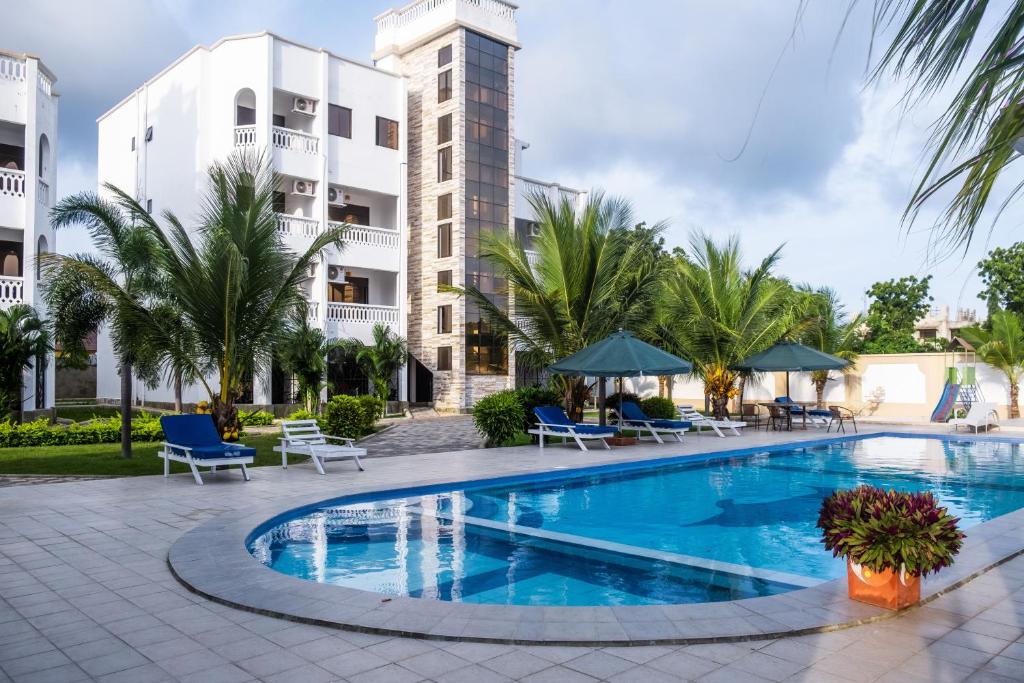 a swimming pool in front of a building at Leomilo Holidays in Diani Beach