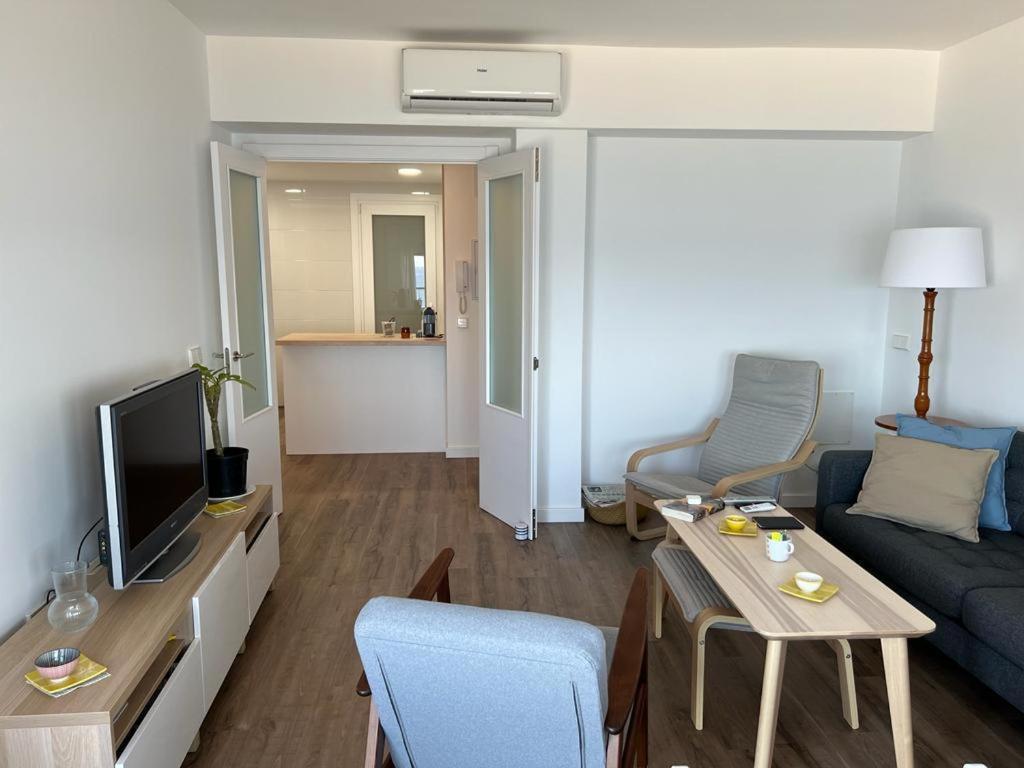 a living room with a blue couch and a tv at SAN MIGUEL PLAYA ALMERIA in Almería