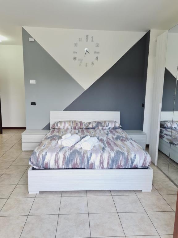 1 dormitorio con 1 cama con reloj en la pared en La casa di Ida Intero appartamento en Vigevano