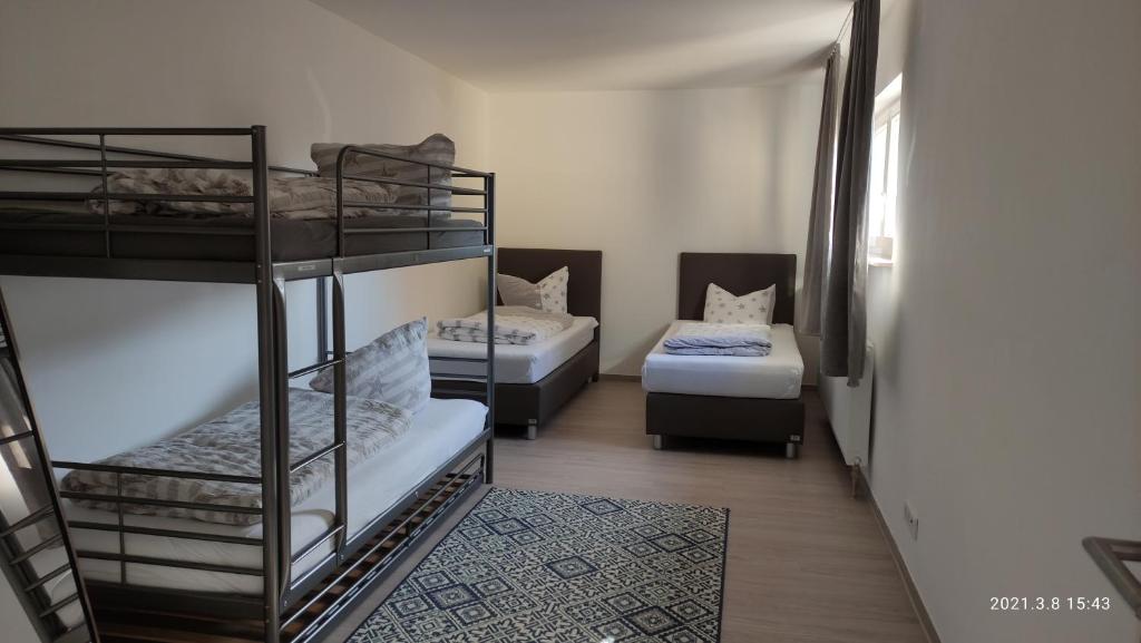 a room with three bunk beds and a couch at 2 Zimmer Wohnung an der Schweizer Grenze in Gottmadingen