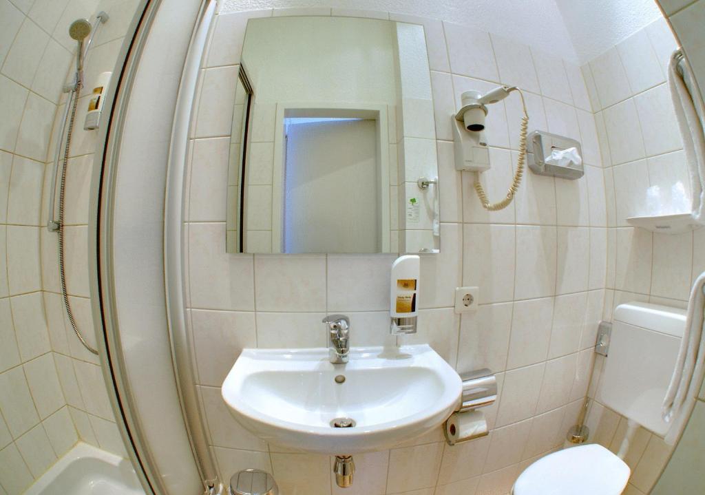 a bathroom with a sink and a mirror at Hotel Terminus am Hauptbahnhof & ZOB in Hamburg