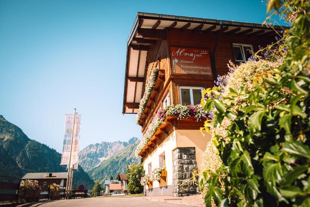 a building with flowers on the side of a street at Ferienhotel Almajur in Mittelberg