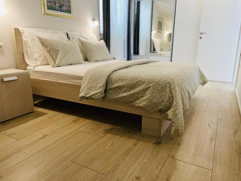 a bed in a bedroom with a wooden floor at Apartment Marina in Korčula